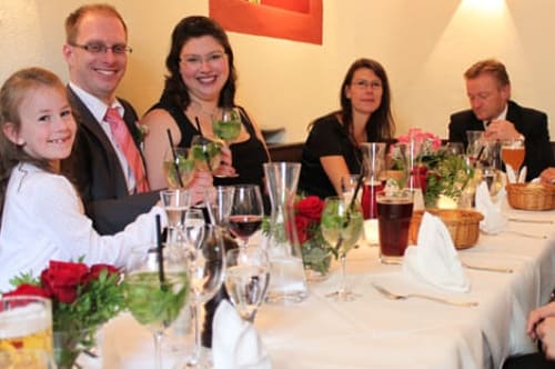 Familie stößt an einer festlich gedeckten Tafel an